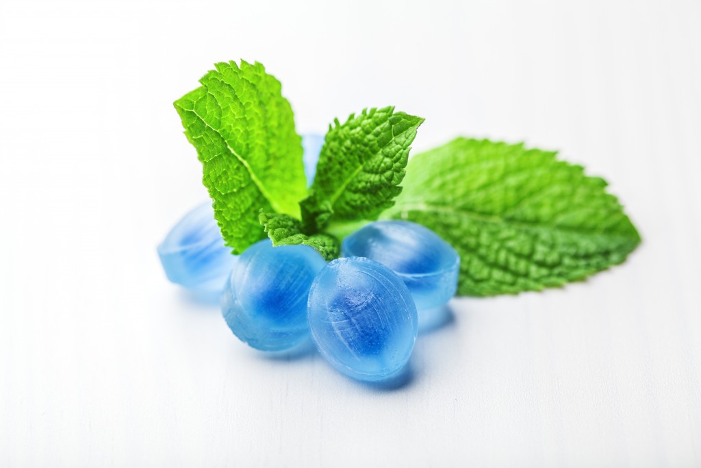 Blue candy fresh balsamic syrup with mint leaves on a white background